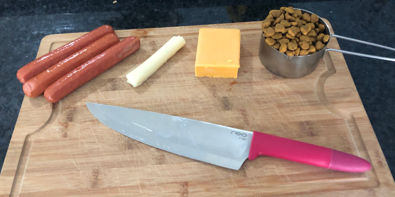 Hot dogs, cheese and kibble on cutting board